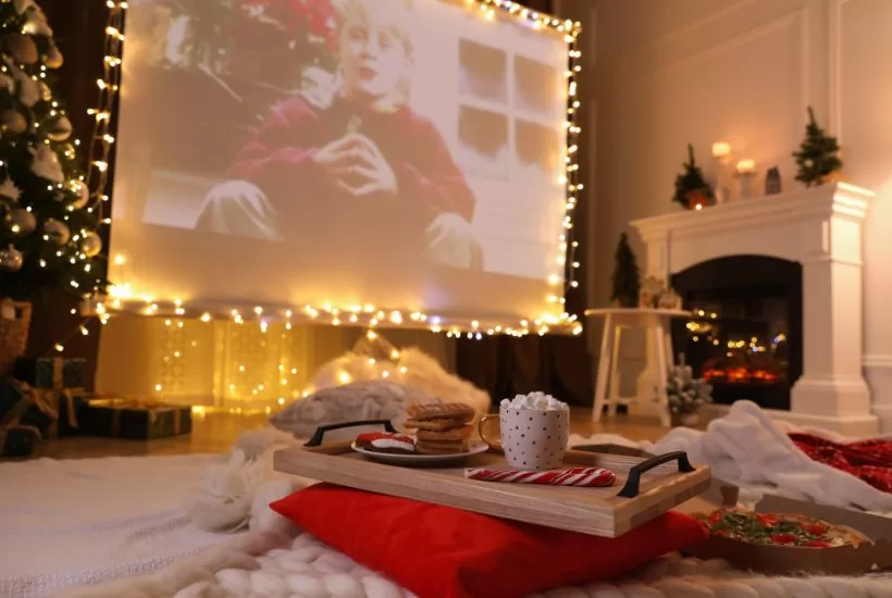 Family watching home alone together in the holiday while being cozy and drinking hot chocolate and cookies.