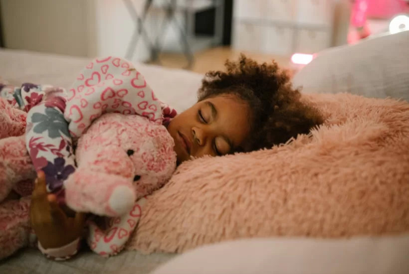 Child sleeping peacefully in a cozy bedroom to support healthy sleep patterns