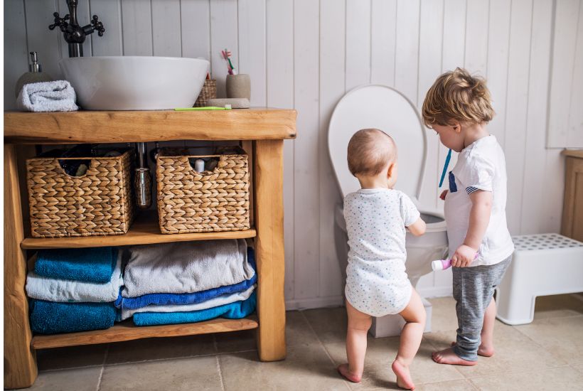 Children exploring toilet to transition from potty cheir to toilet